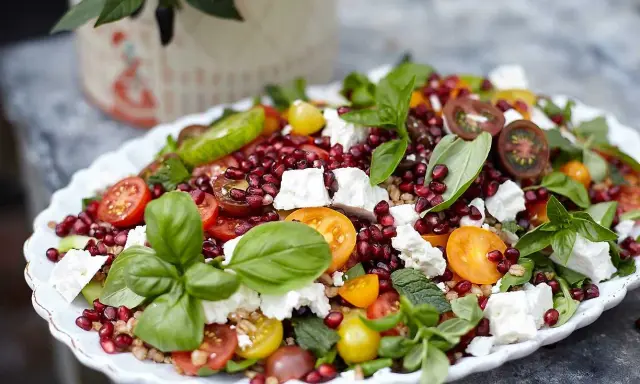 En matig sallad med fetaost, granatäpple, körsbärstomater och färska örter. En festlig och färgstark rätt.