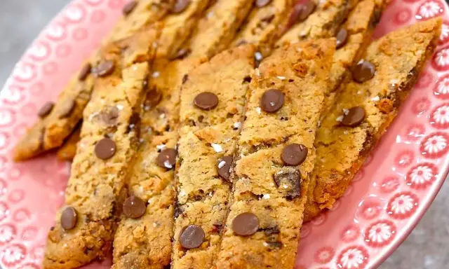 En rosa tallrik fylld med hembakade kolasnittar med choklad. Perfekta för fikat!