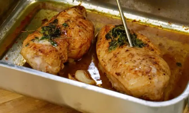 Två saftiga kycklingbröst i en ugnsform, kryddade med örter och vitlök. Perfekt mat med kyckling för en härlig middag.