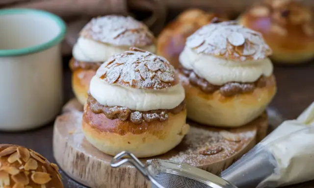 Fredriks fika med semlor recept: fluffiga bullar fyllda med mandelmassa och grädde, pudrade med florsocker och mandelspån.