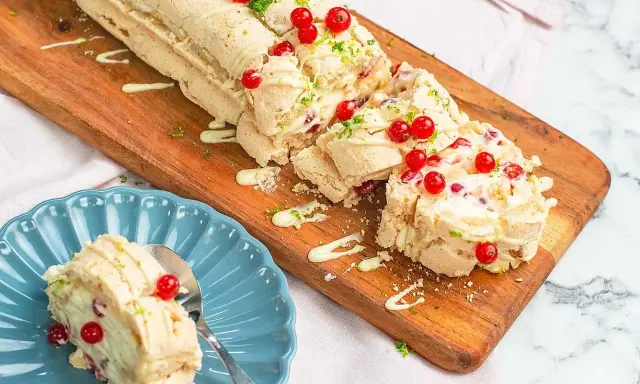 En läcker budapestrulle med hallon och vit choklad, toppad med färska röda vinbär och rivet limeskal.