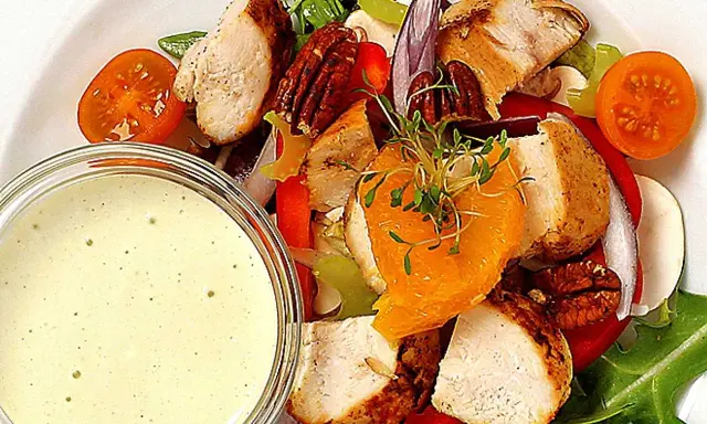 En härlig kycklingsallad med saftiga kycklingbitar, nötter, apelsin och en krämig dressing till kycklingsallad.