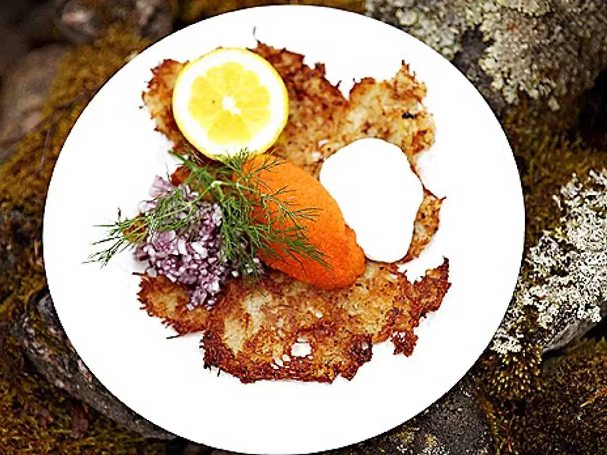 En tallrik med krispiga r&aring;rakor, serverade med rom, gr&auml;ddfil, citron och dill. Ett h&auml;rligt r&aring;raka recept f&ouml;r en festm&aring;ltid.
