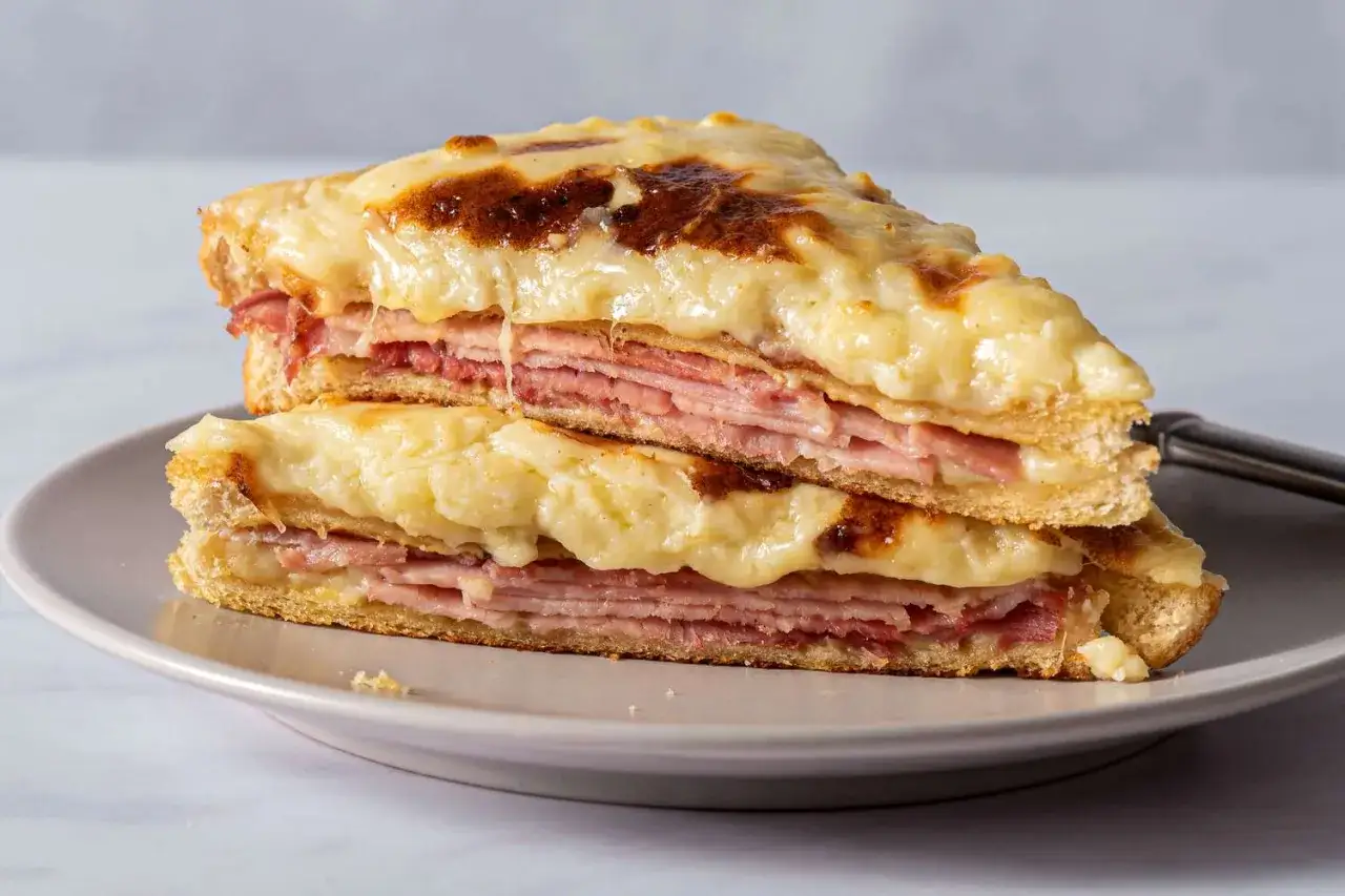 En gyllene croque monsieur staplad p&aring; en annan, med sm&auml;lt ost och skinka.