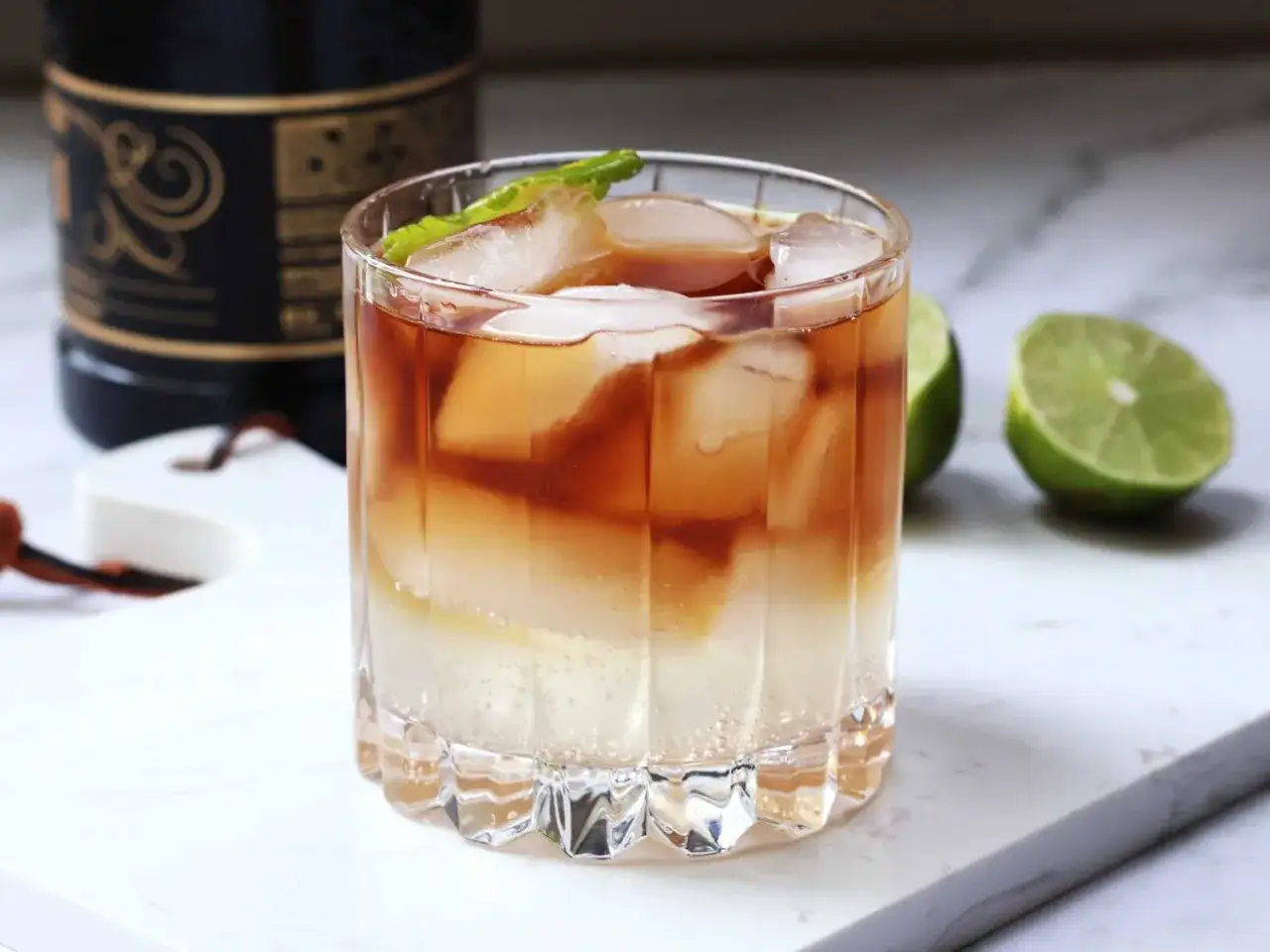 En m&ouml;rk och stormig drink med is och lime, perfekt f&ouml;r en mysig kv&auml;ll.