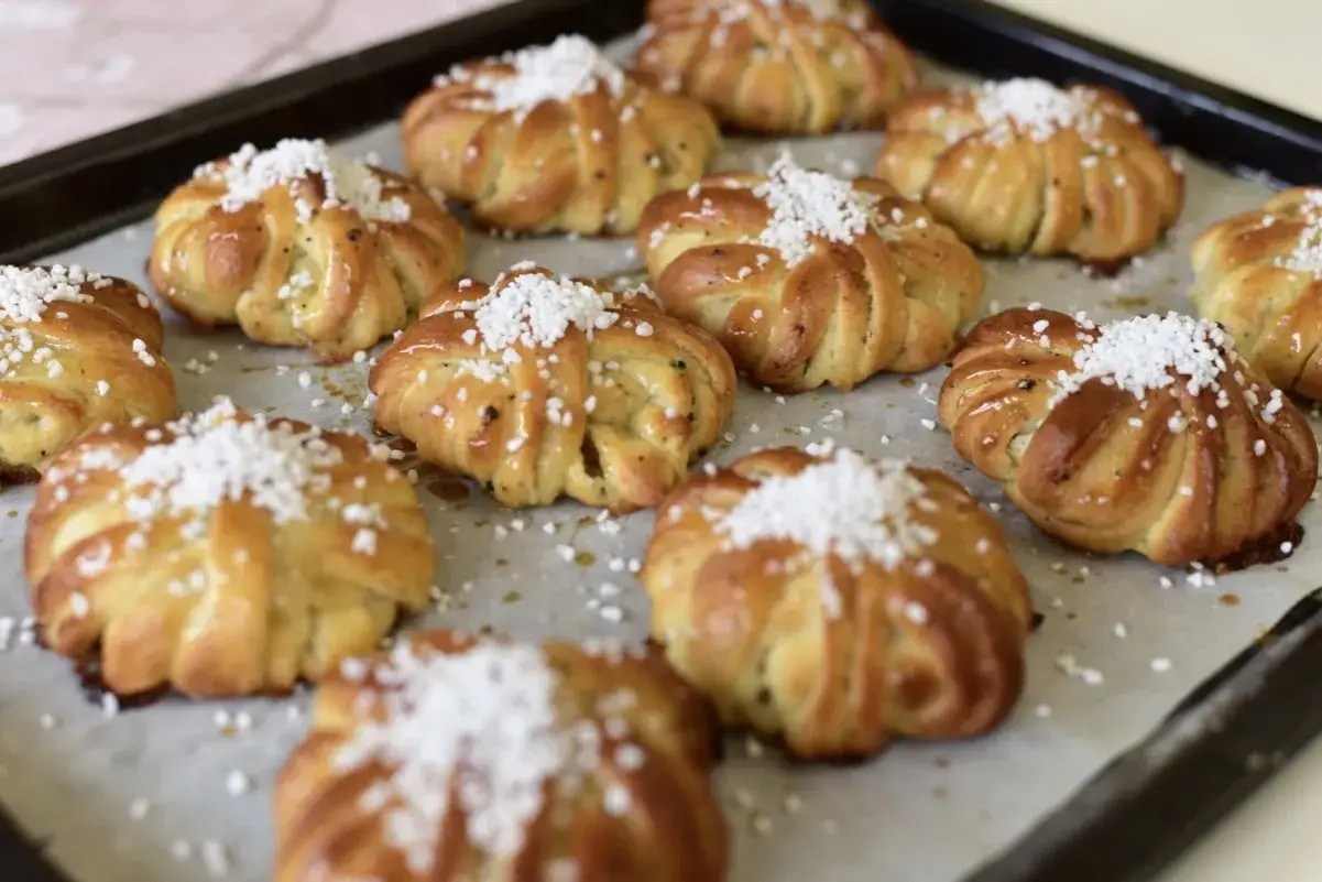 Fredriks fika: nybakade kanelbullar med kardemumma och pärlsocker på en plåt.