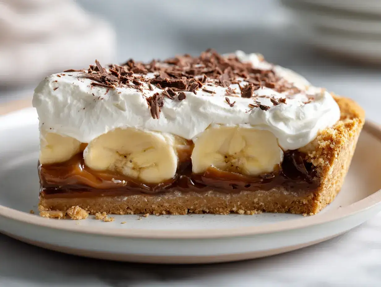En bit banoffee paj med fluffig gr&auml;dde, banan, kolas&aring;s och chokladstr&ouml;ssel.