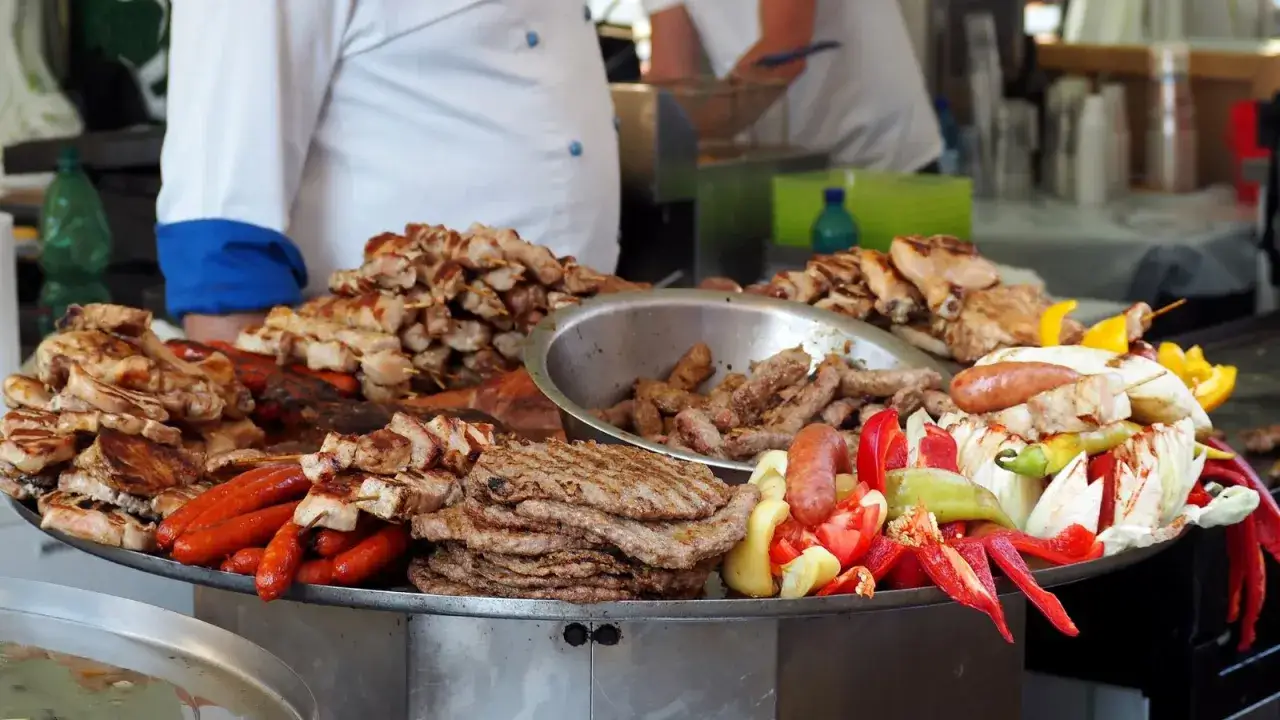 Stor bricka med grillad mat: cevapcici, korvar, kyckling och grönsaker. Perfekt för ett cevapcici recept!