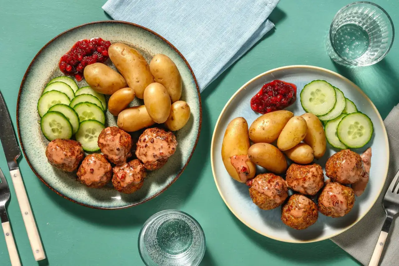 Två tallrikar med köttbullar, potatis, gurka och lingonsylt. Perfekt middagstips helg för en mysig kväll.