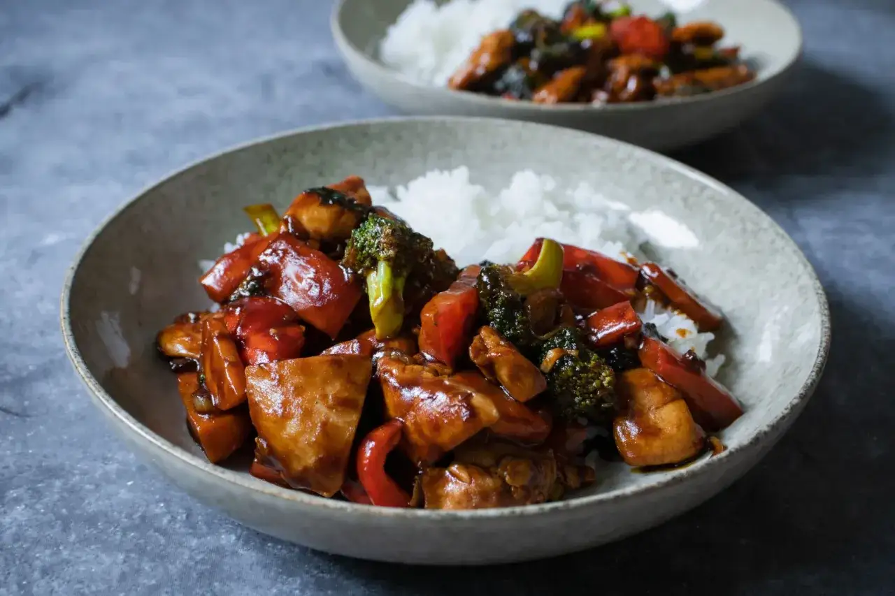 En sk&aring;l med kyckling wok med ris, broccoli och r&ouml;d paprika. En annan sk&aring;l med samma r&auml;tt syns i bakgrunden.