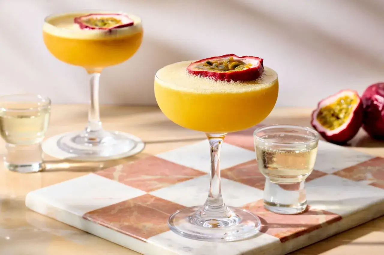 Två Pornstar Martini-drinkar med passionsfrukt, serverade med en shot.