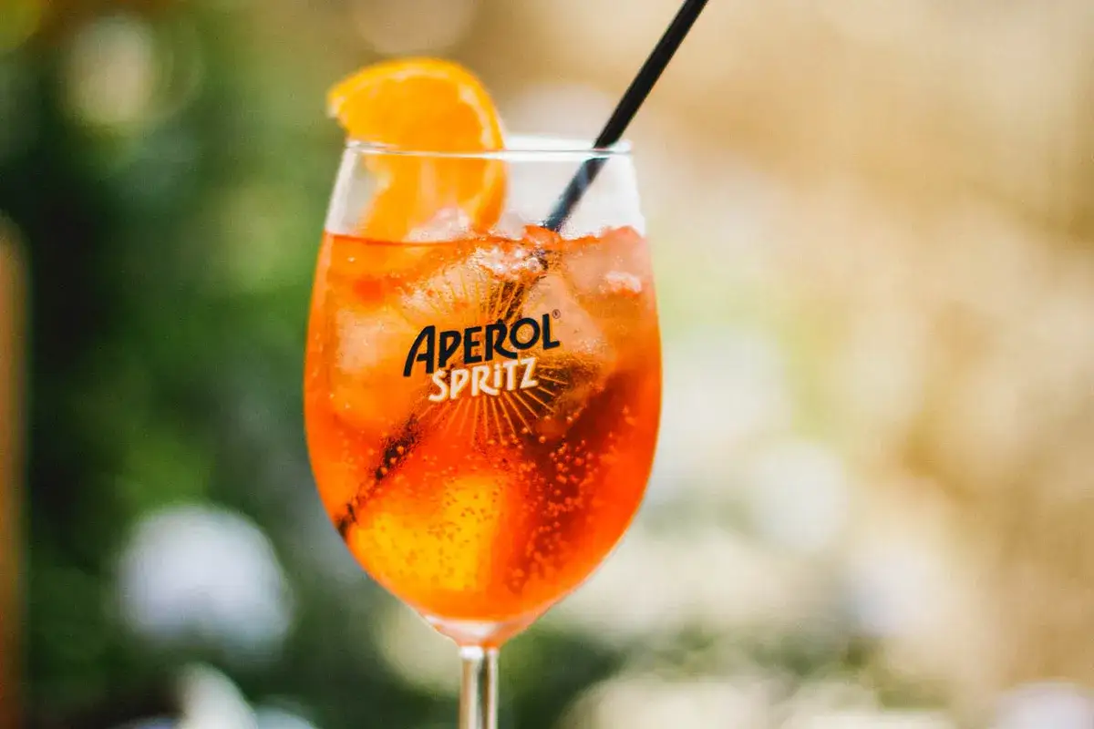 Ett glas Aperol Spritz med is, apelsinskiva och sugrör. Perfekt för en solig dag, vilket sodavatten till aperol spritz?