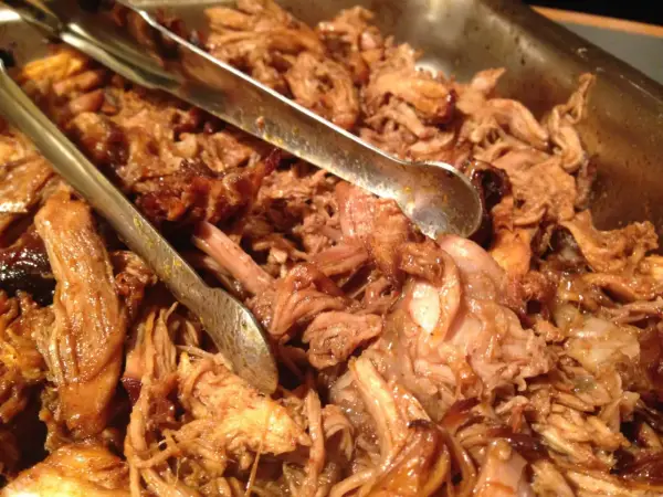 En stor skål med saftig pulled pork, perfekt för Fredriks fika. Tång ligger redo att servera.