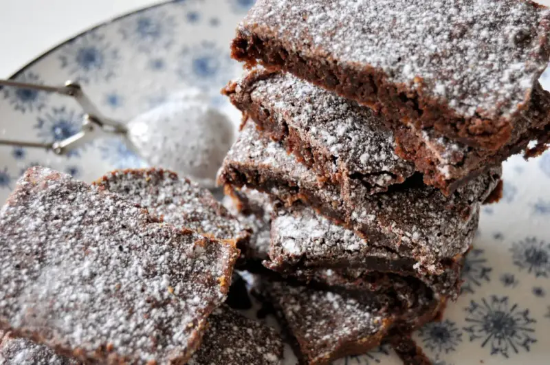 En hög med saftig kladdkaka i långpanna, pudrad med florsocker. Perfekt för fikat!