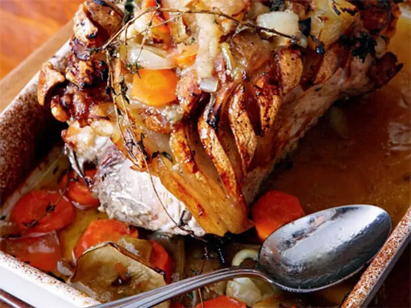 En saftig skinkstek med knaprig svål, serverad med rotfrukter och en sked redo att ösa. Ett perfekt skinkstek recept för helgen.